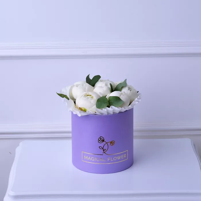 Букет из 9 белых пионов в фиолетовой шляпной коробке с эвкалиптом