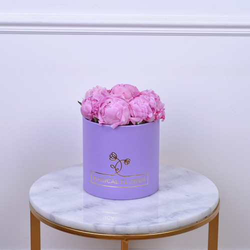 Букет из 7 розовых пионов в фиолетовой белой шляпной коробке