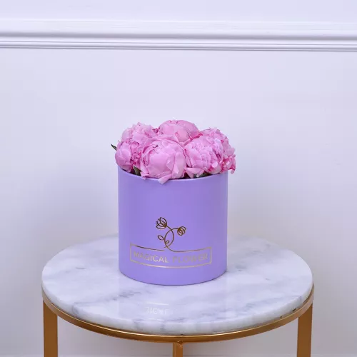 Букет из 7 розовых пионов в фиолетовой шляпной коробке