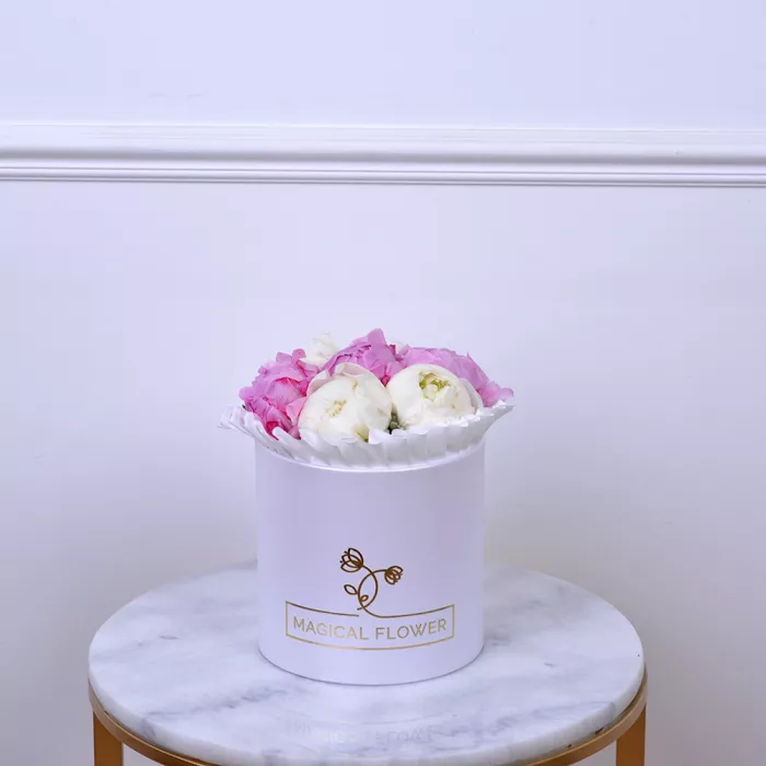 Букет из 9 разноцветных пионов в белой шляпной коробке