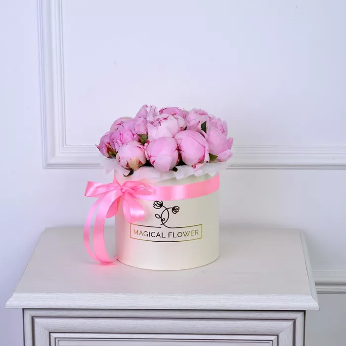 Букет из 15 розовых пионов в кремовой шляпной коробке